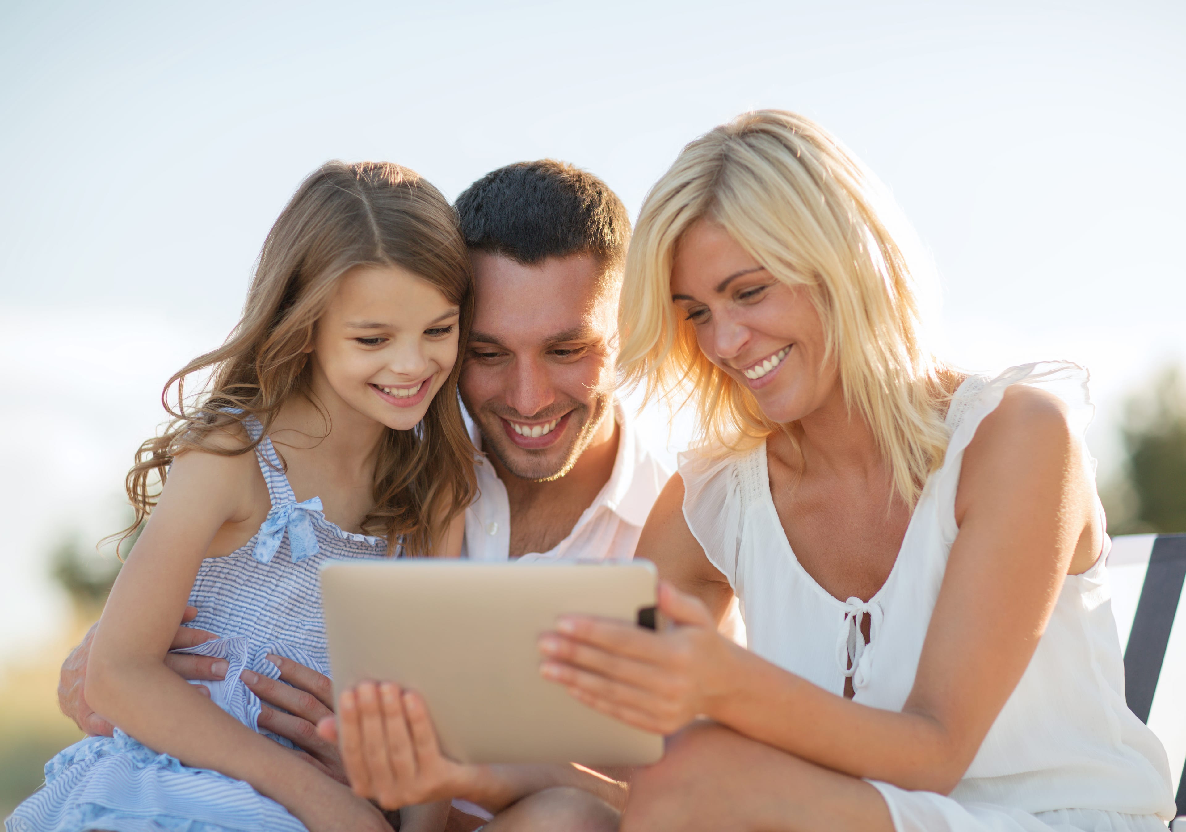 Parents and their daughter looking at a tablet together